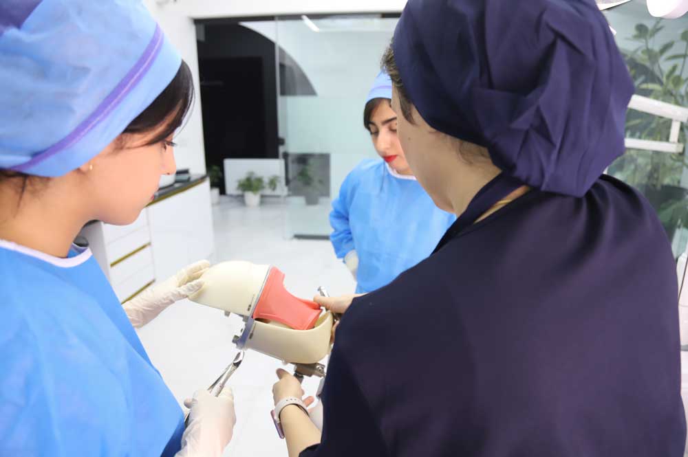 Dentists practicing hands-on ADC Practical exam techniques with a dental training model at Mehr Dental Academy